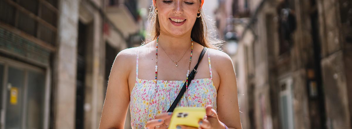 Frau schaut auf Smartphone in einer europäischen Altstadt
