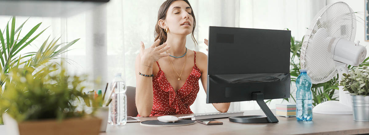 Frau leidet unter Hitze im Büro